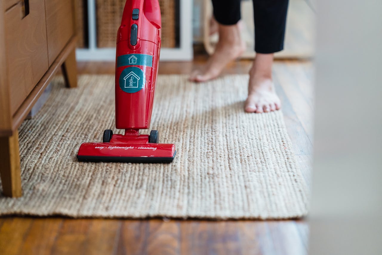 about-01 A red vacuum cleaner on a carpet in a stylish home setting with barefoot user.